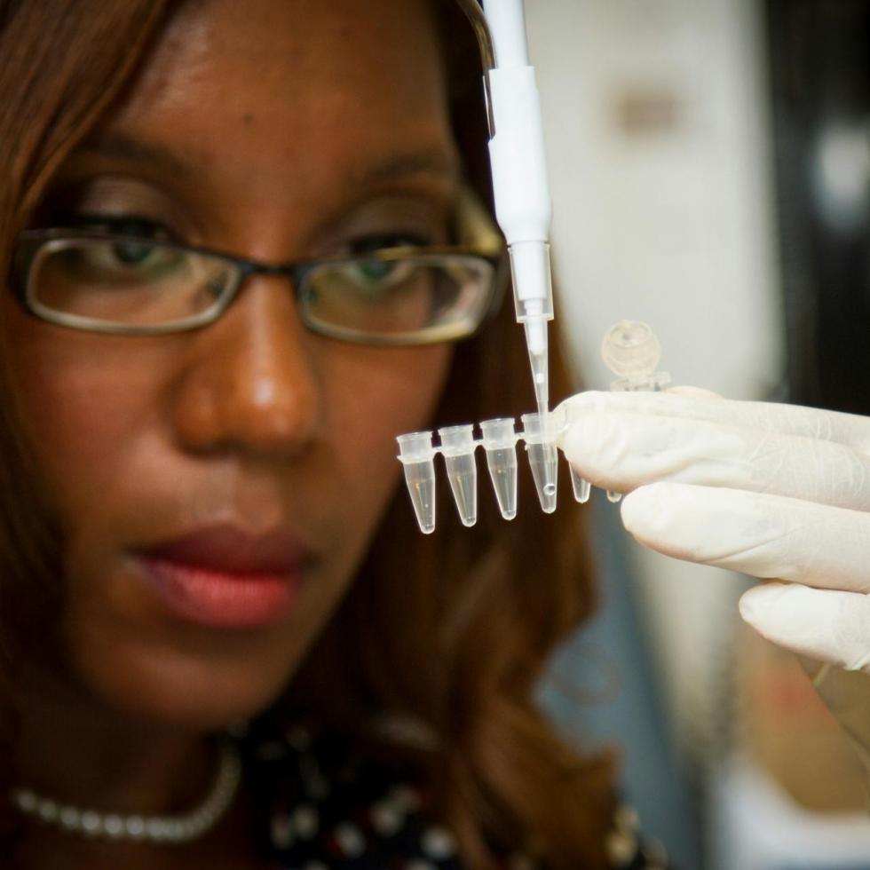 Female scientist putting liquid in a test tube