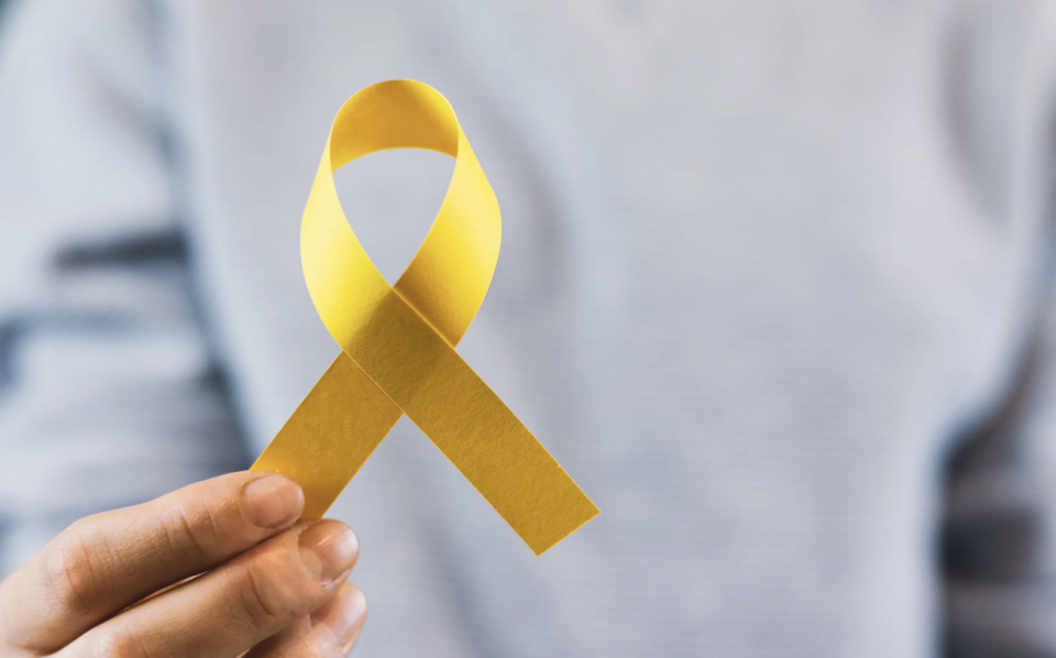 Photo of someone holding a yellow ribbon