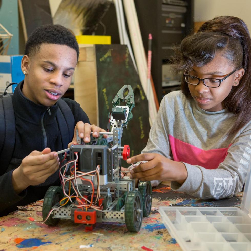 Ninth-grade boy and girl assemble a robot