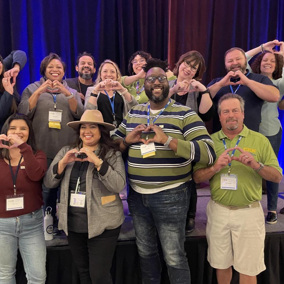 Image of the CAN and ASAPconnect teams making hearts shapes with their hands. 