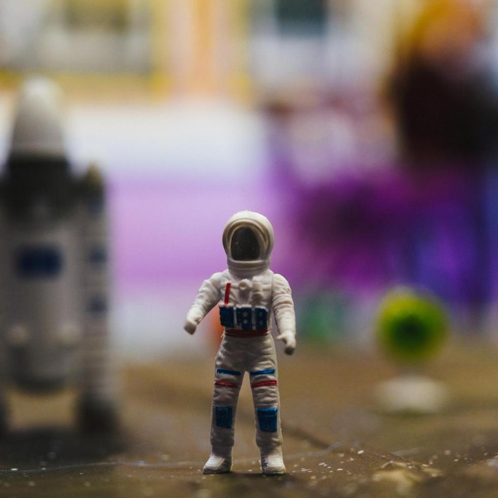 A clay astronaut with a spaceship behind it