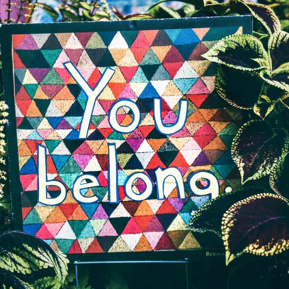 A colorful sign with the words "You belong"