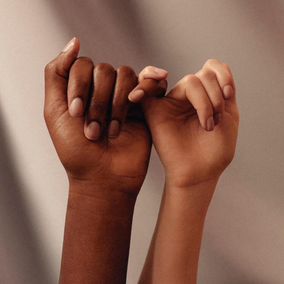 Photo of two hands holding pinkies