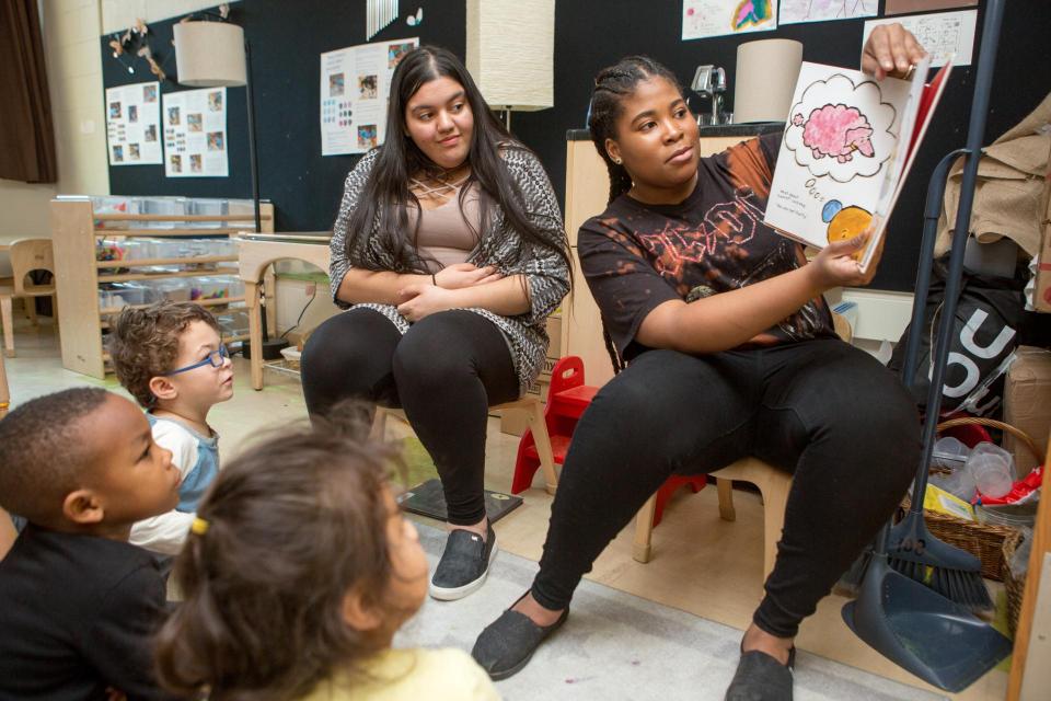 High school student teachers read a book to a preschool class.