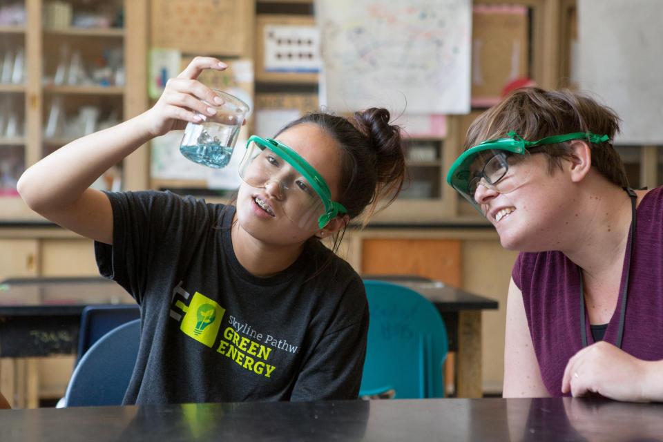 A student looks for a chemical reaction in a beaker during an experiment.