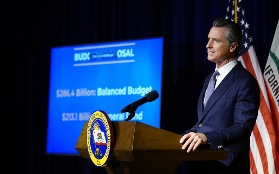 Image of Gov. Gavin Newsom standing at a podium during a news conference.