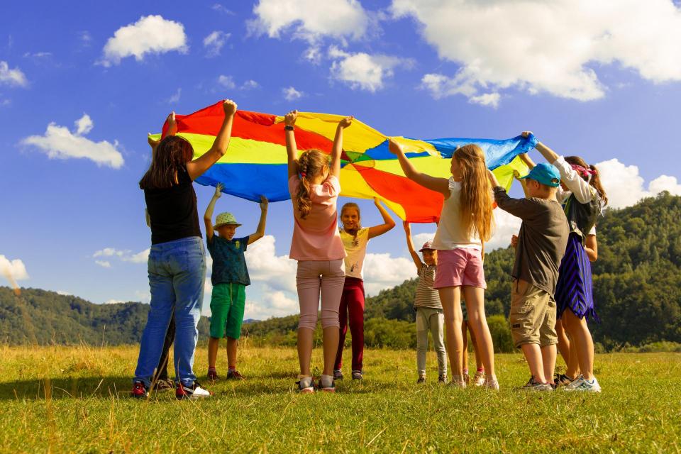 Children outside with a tarp playing a game