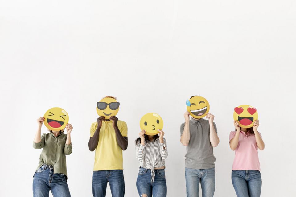 Friends covering faces with emoji signs