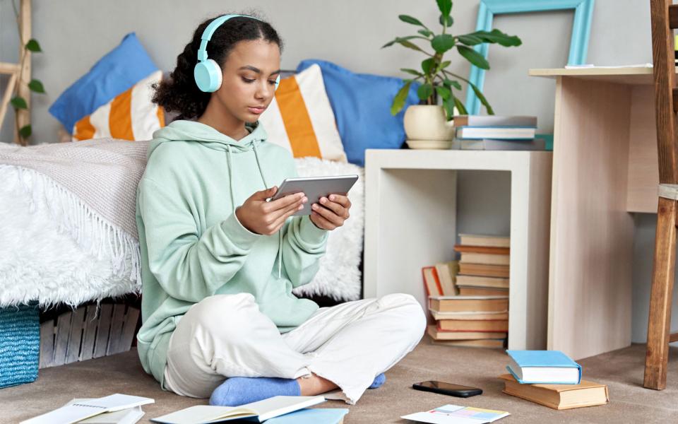 Photo of girl sitting down on floor looking at her phone