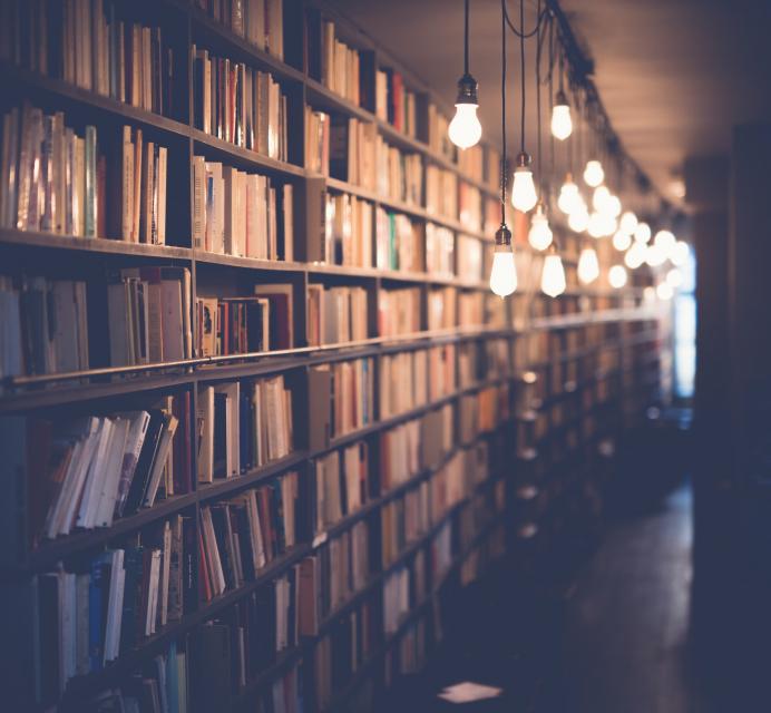 Library with bookshelves and hanging lights.