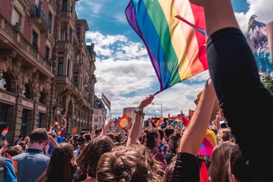 People celebrating and waving a Pride flag in the air