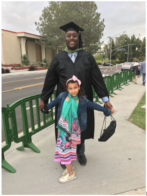 Troy in a cap and gown with daughter