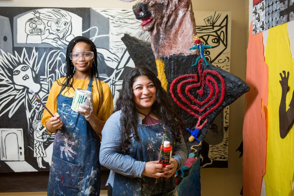 Photo of 2 girl artists showing off their mural and art projects