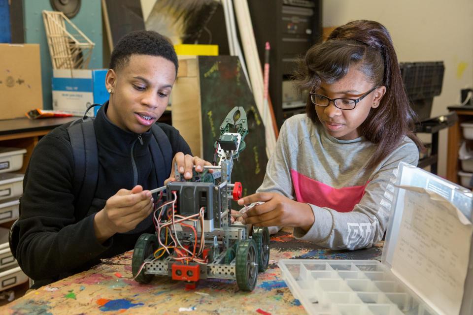 Ninth-grade boy and girl assemble a robot