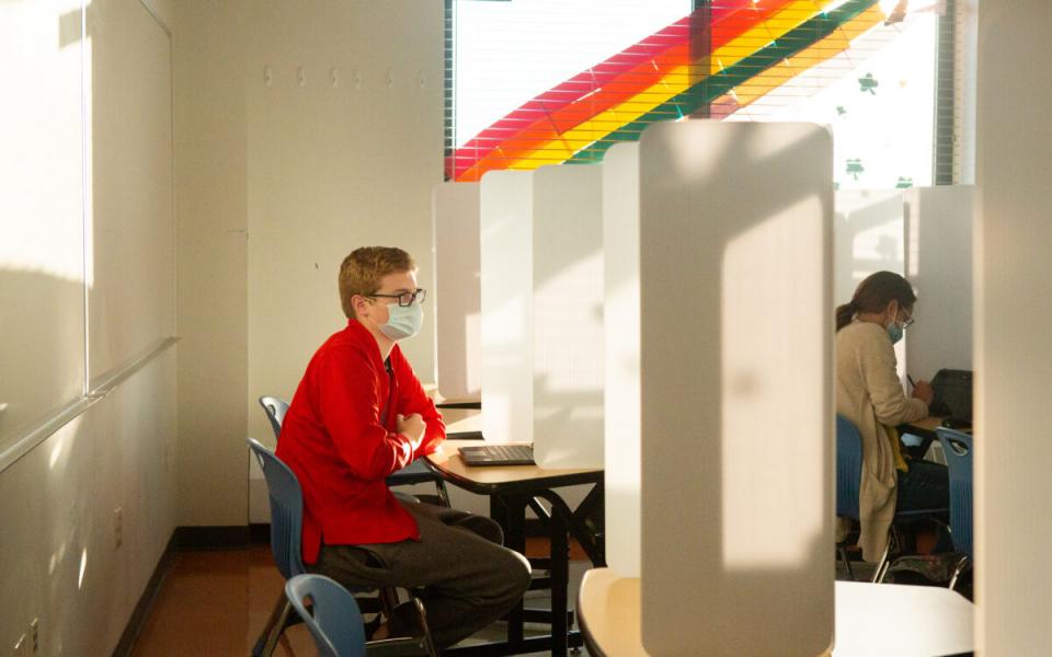 Student taking test behind protective shield