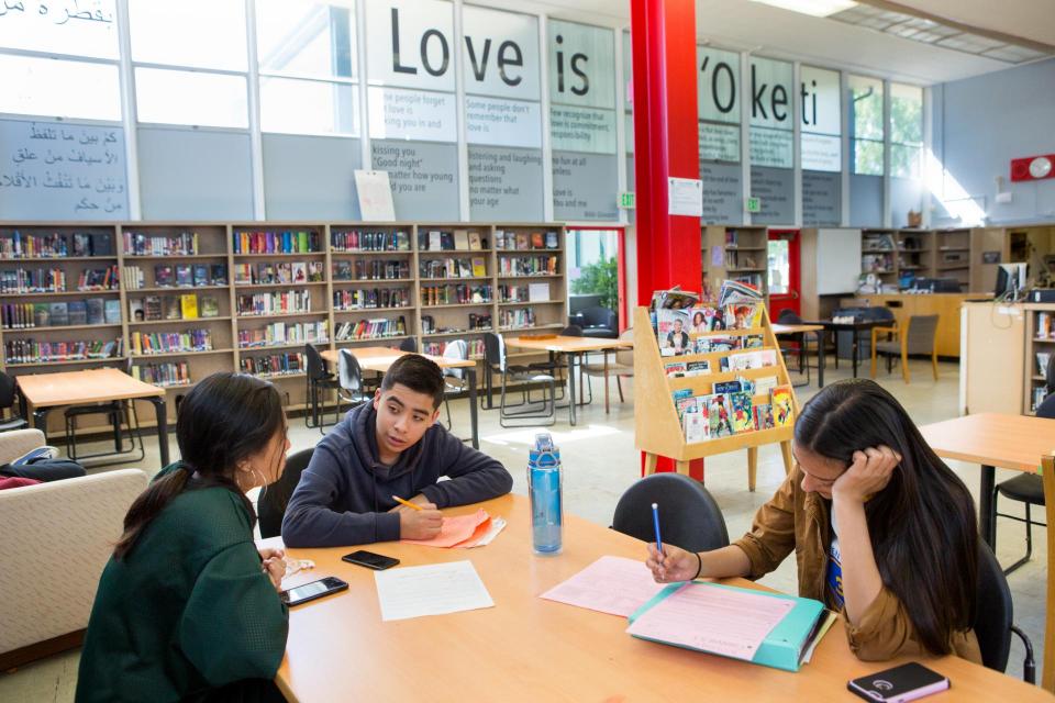 High school students writing in library