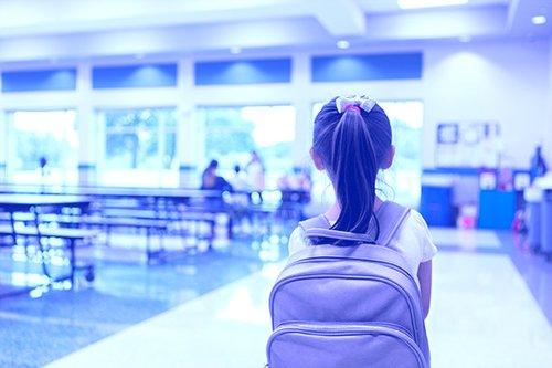 Student entering cafeteria with back facing camera