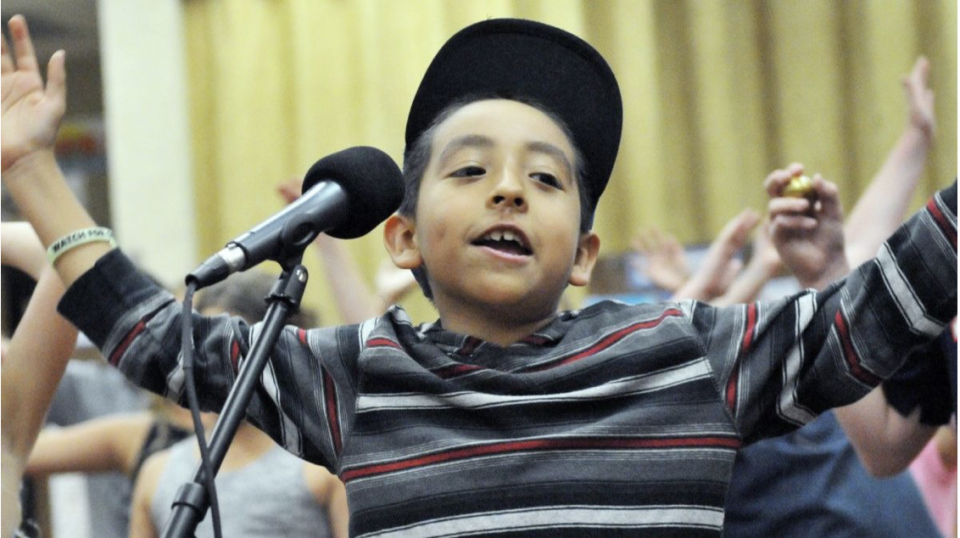 Child in front of a microphone cheering