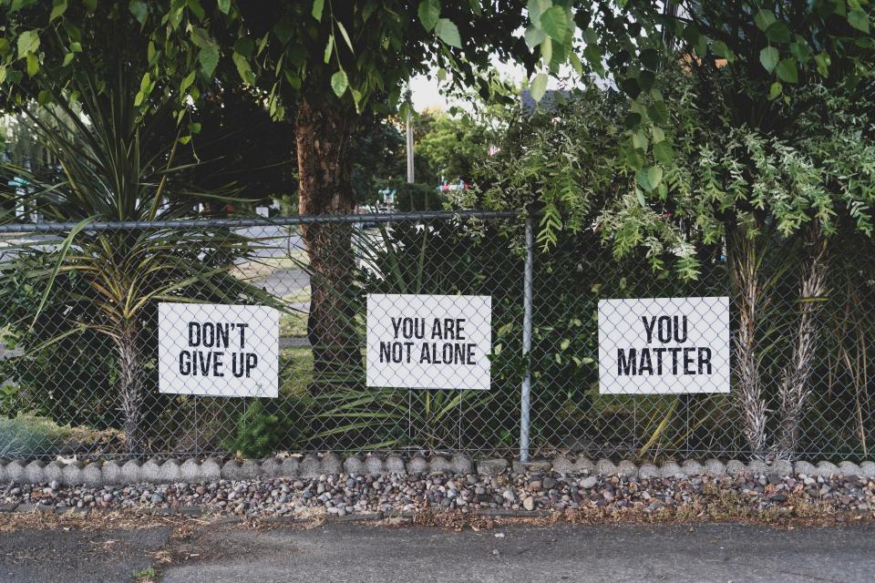 Fence with the signs "You are not alone" "Don't give up" "You matter"