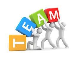 Four people holding squares that spell out " T E A M "