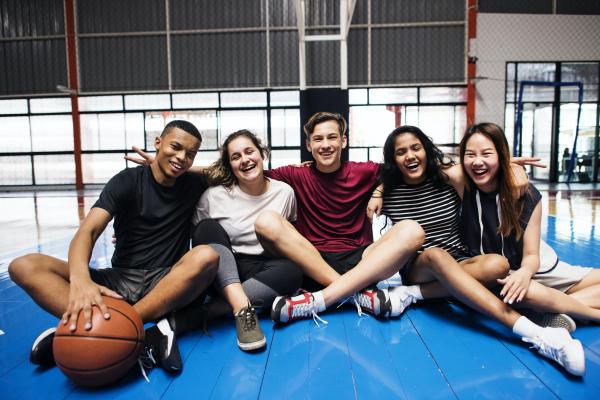 Students smiling sitting in the gym