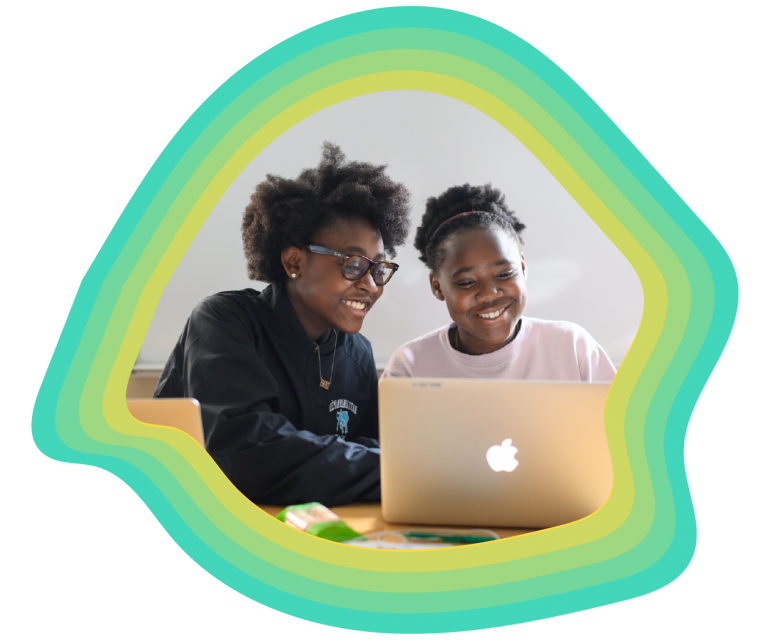 Two girls sitting in front of a laptop