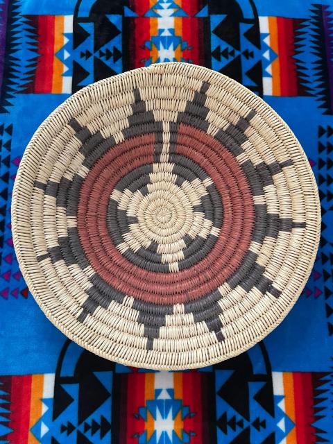 Navajo Wedding Basket: an intricately woven basket with fibers in black, tan, and red