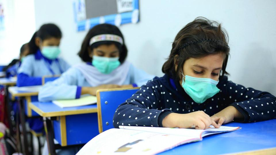 Children reading books with masks on