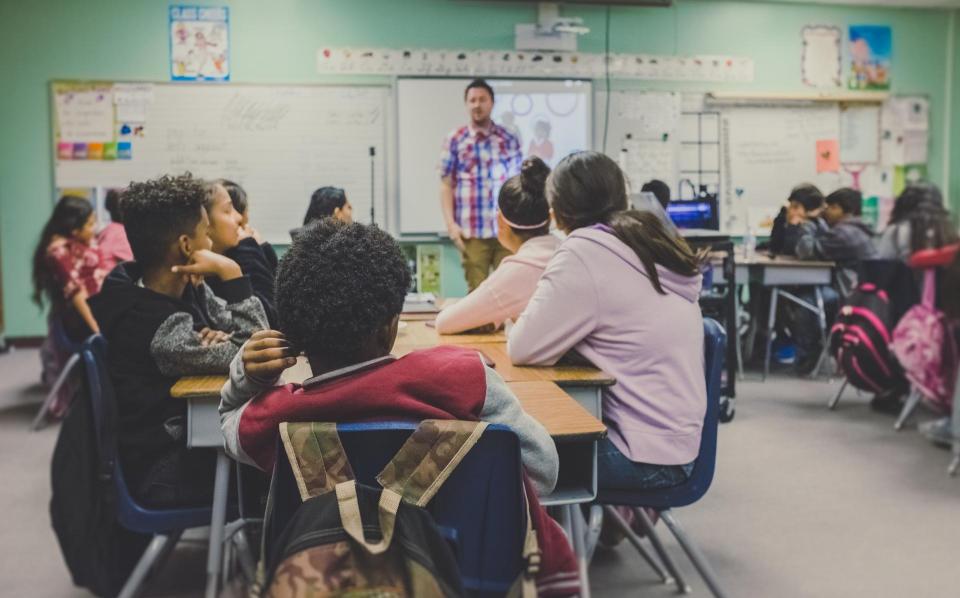 a teacher standing in the front of a classroom 