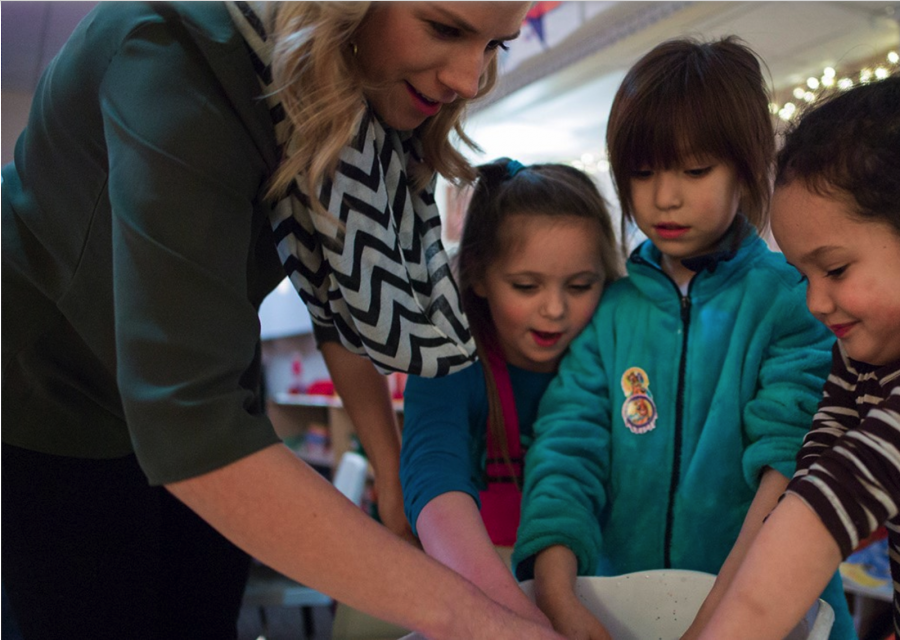 Teacher and Students Interacting with Hands Mixing in a Bowl