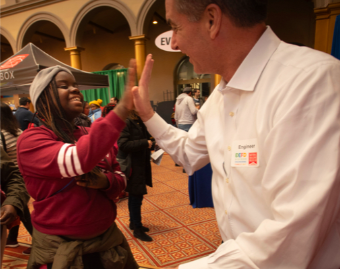 Student high-fiving a teacher