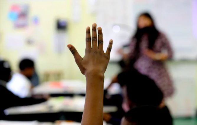 Close-up shot of a student raising their hand