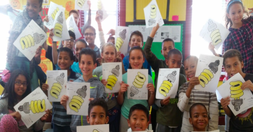 Students and teachers holding papers with lightbulbs on them