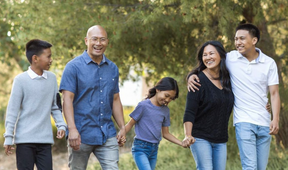 Photo of happy family walking together hand-in-hand