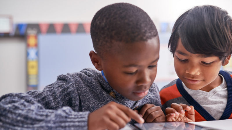 Two students looking at a tablet device