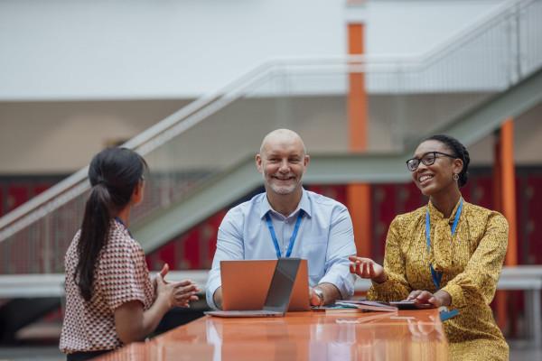 Three teachers smiling sitting around a table